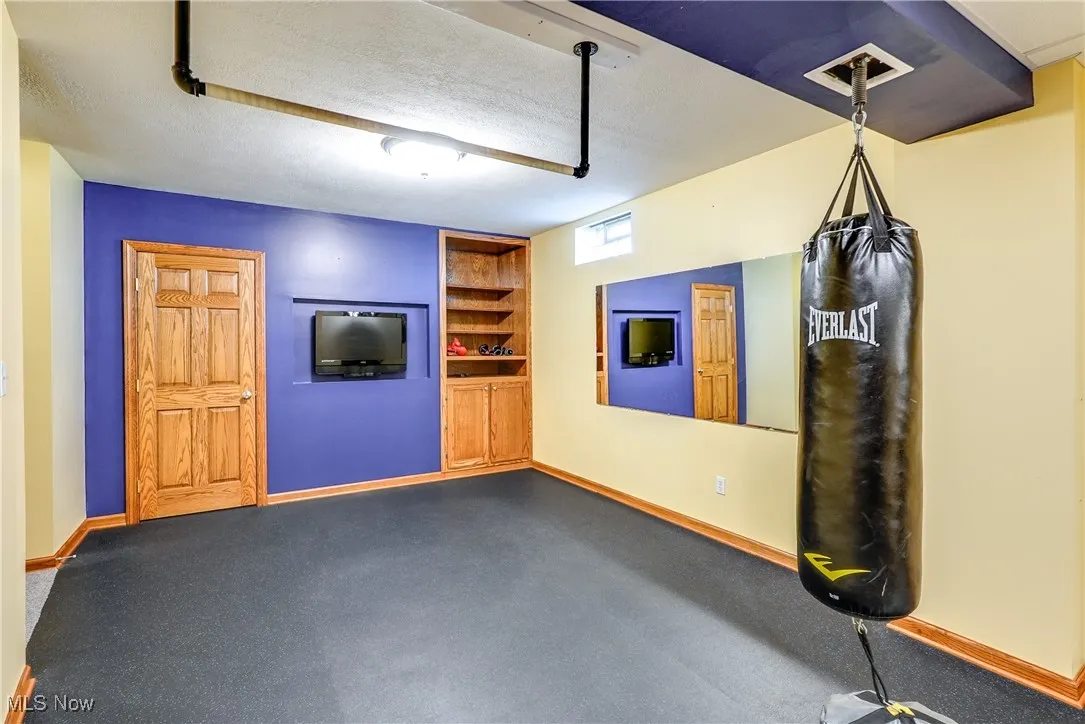 Exercise room in lower level with built-ins, wet bar, space for refrigerator and half bath