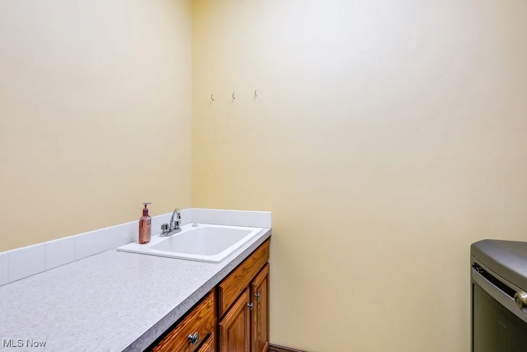First floor laundry with cabinets and laundry sink