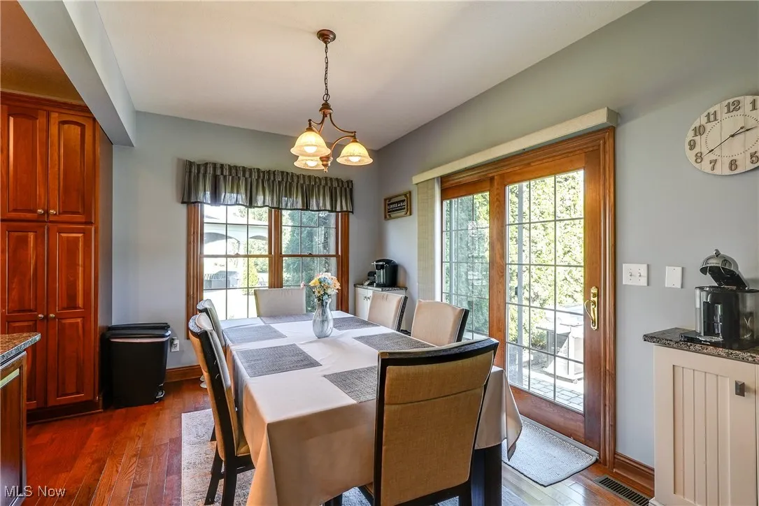 Large dinette with wood floors, built in cabinets, and sliding doors to entertaining patio.