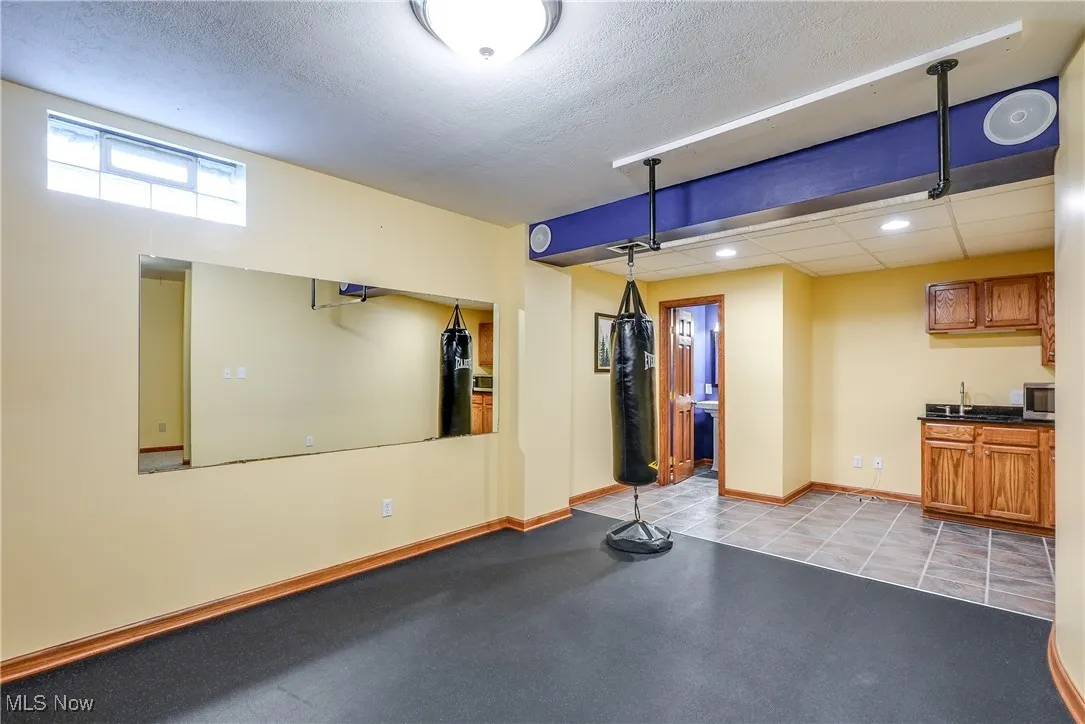 Exercise room in lower level with built-ins, wet bar, space for refrigerator and half bath