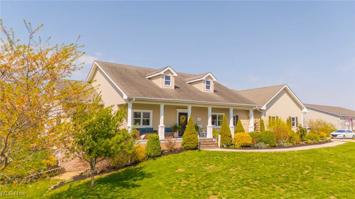 New england style home with a porch and a front yard