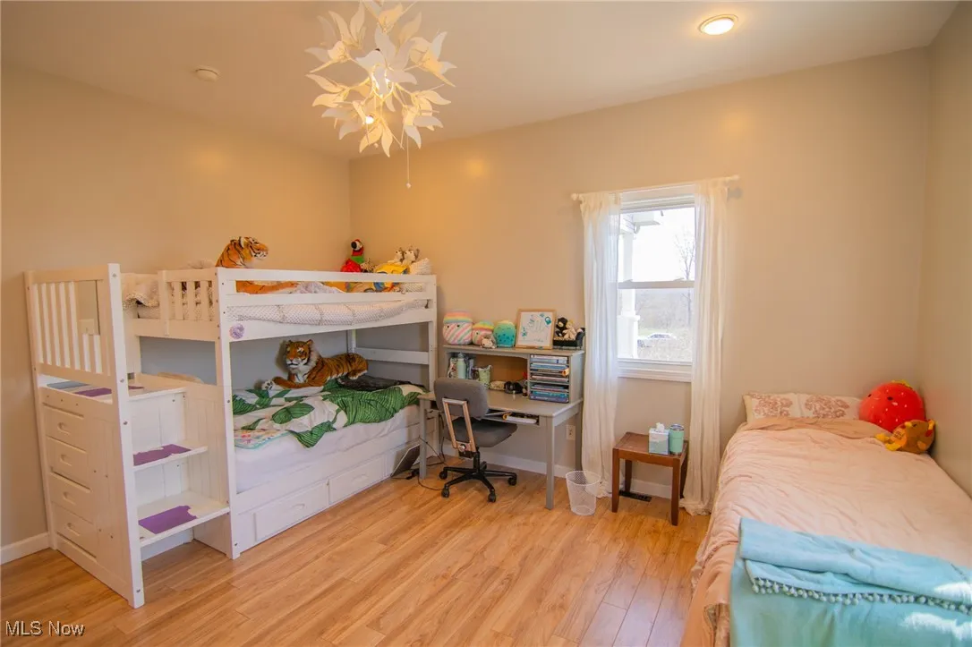 Bedroom with wood finished floors and baseboards