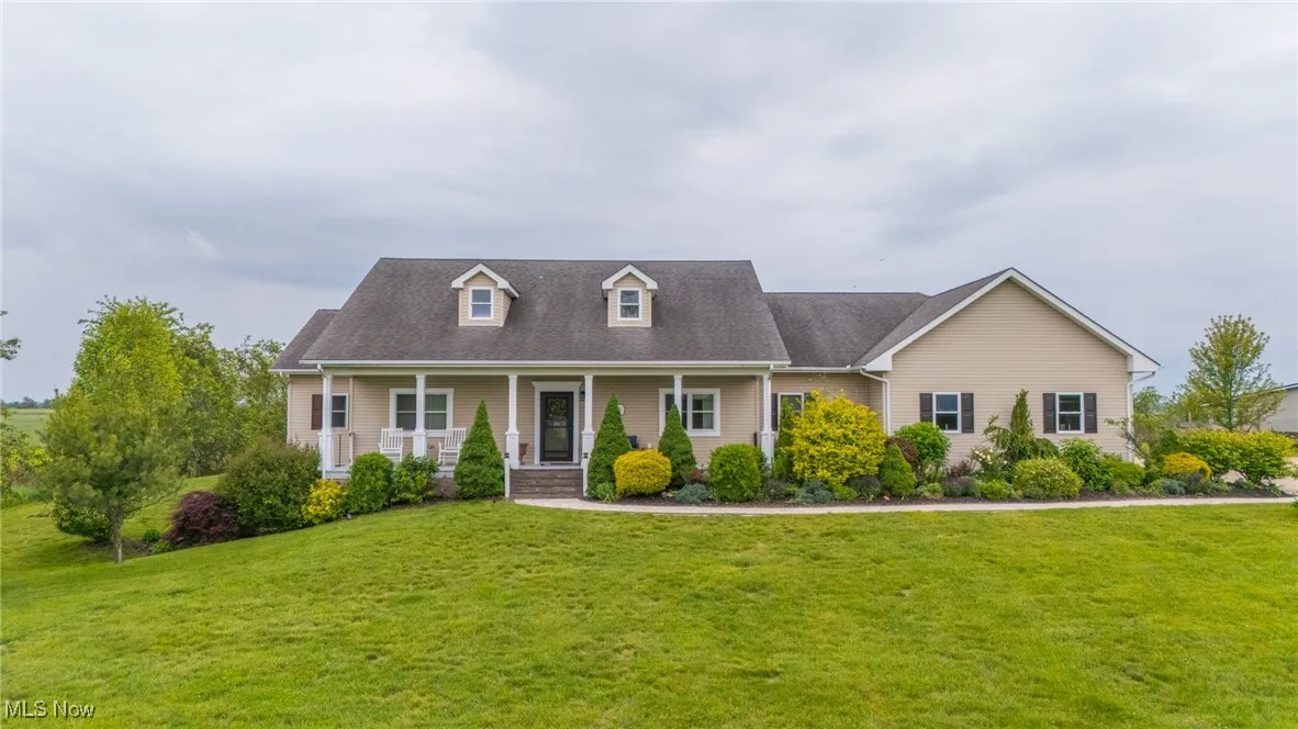 Cape cod-style house with covered porch and a front yard