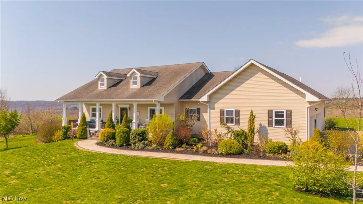 New england style home with covered porch and a front yard