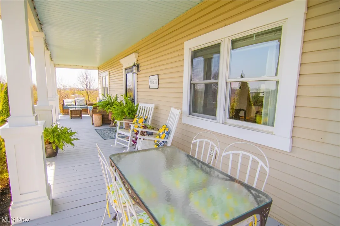 Wooden deck featuring a porch and outdoor dining area