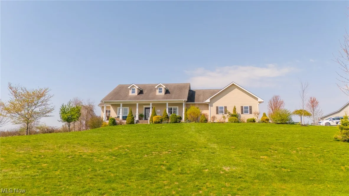 Cape cod house featuring a porch and a front lawn