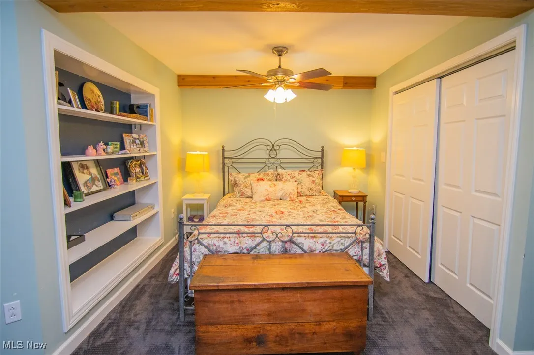 Bedroom with dark colored carpet and a closet