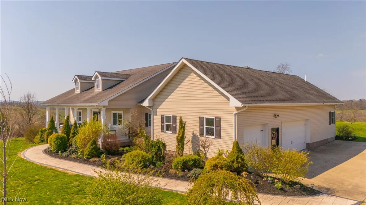 View of side of home with concrete driveway, a yard, and a garage
