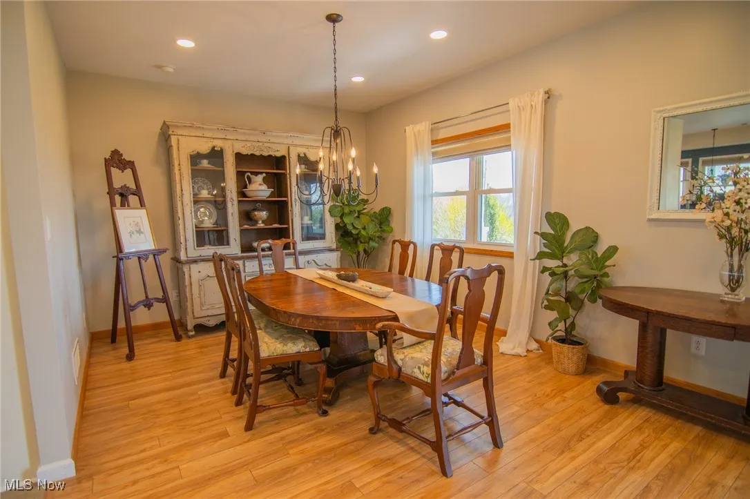 Dining space featuring a chandelier, light wood-style floors, and baseboards