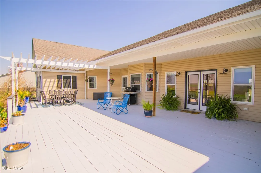 Rear view of property with a pergola, outdoor dining space, and a deck