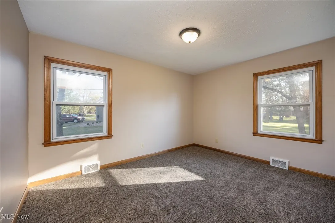 Spare room with visible vents, carpet flooring, and baseboards
