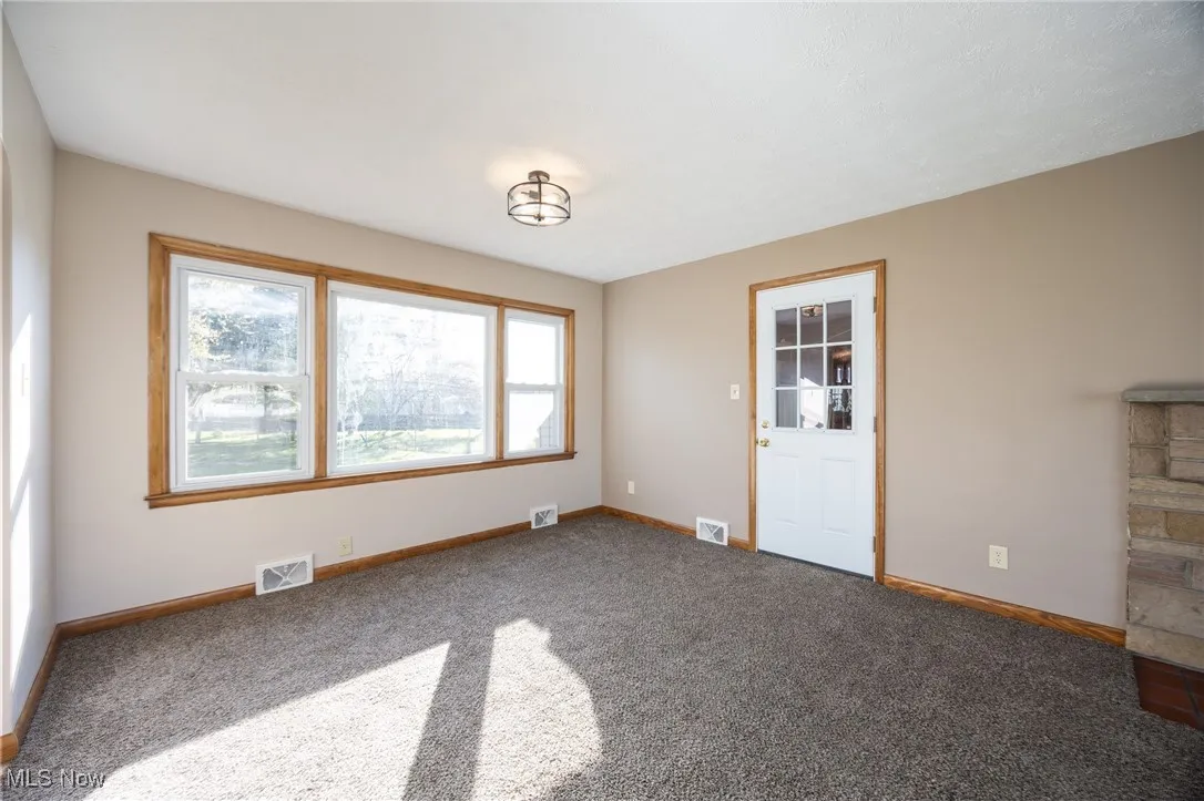 Carpeted dining room featuring a healthy amount of sunlight and visible vents