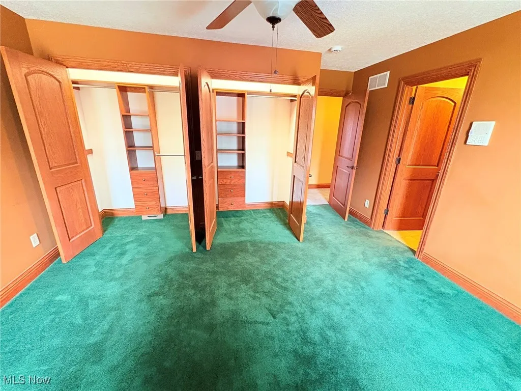 Upstairs second bedroom featuring two large closets with a full private bathroom.