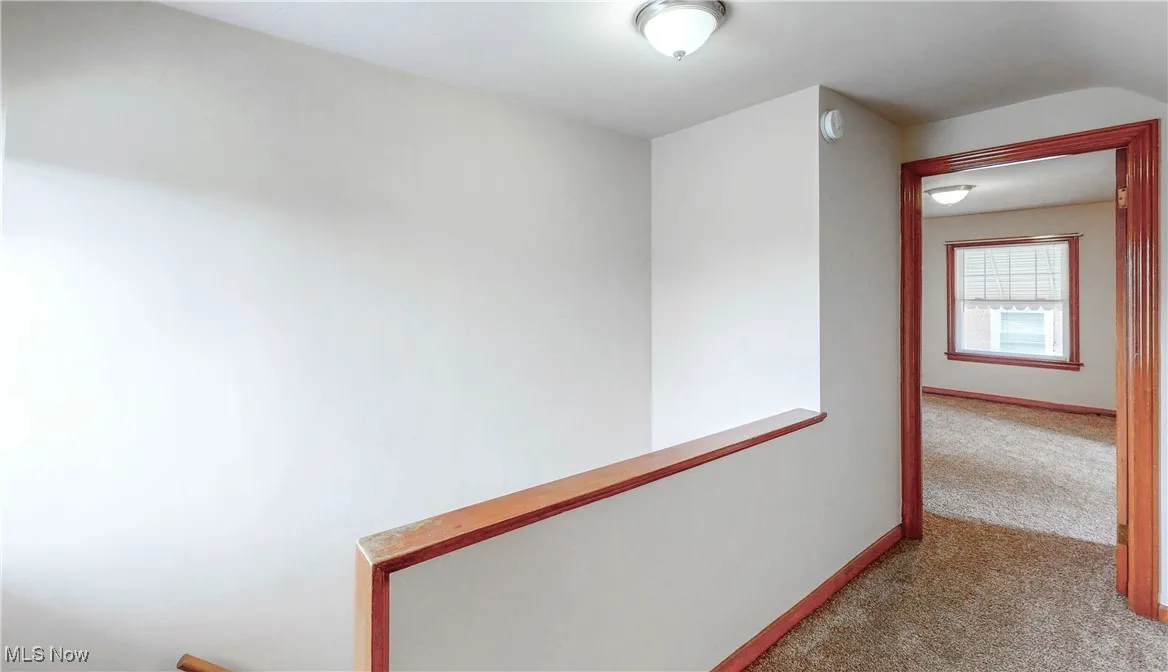 Corridor featuring baseboards and carpet