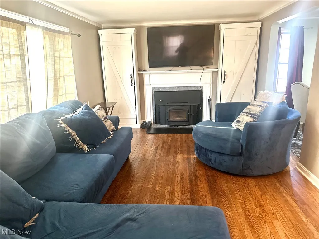 Living area featuring wood finished floors and ornamental molding
