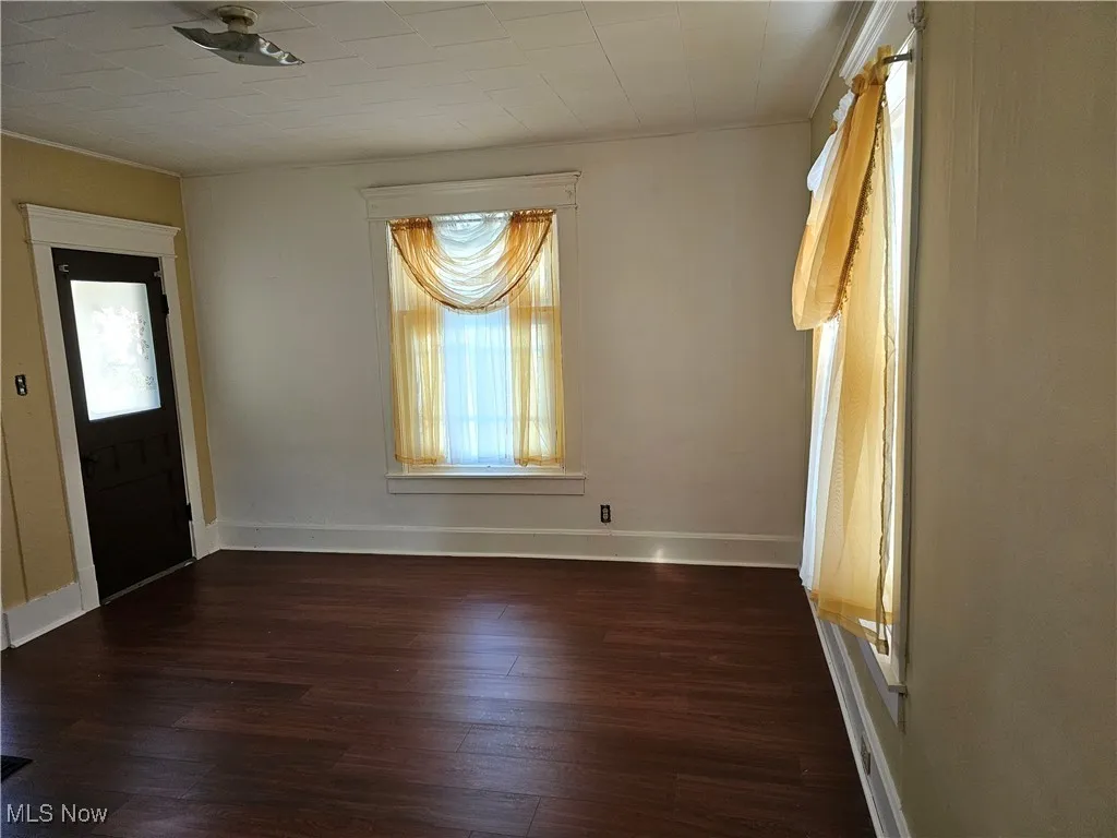 Entrance foyer with baseboards, ornamental molding, and wood finished floors