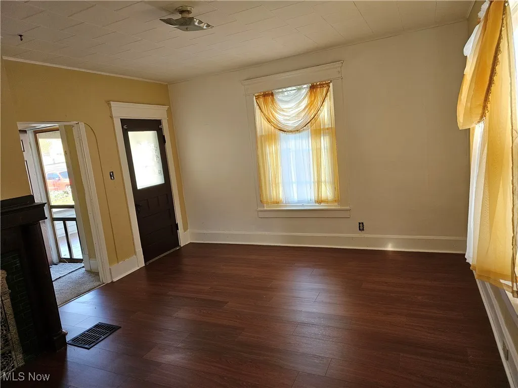 Entrance foyer with hardwood / wood-style flooring, baseboards, crown molding, and visible vents