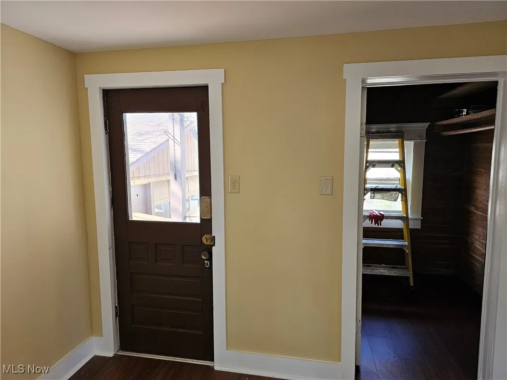 Entryway featuring baseboards and dark wood-style flooring