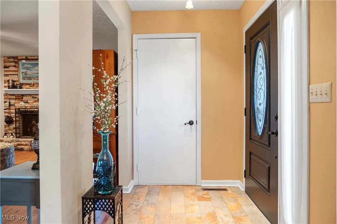 Foyer with baseboards and stone finish floor