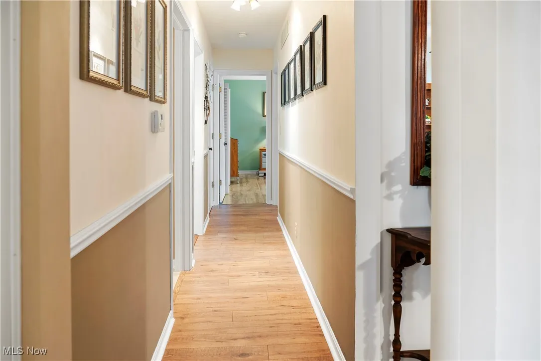 Corridor with baseboards and light wood-style flooring