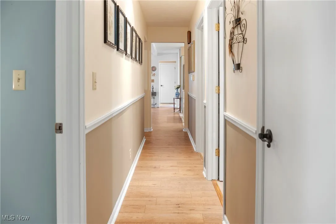 Corridor with baseboards and light wood-style floors