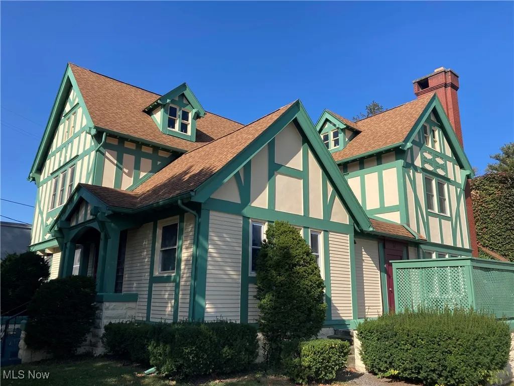 View of front of property featuring a shingled roof and a chimney