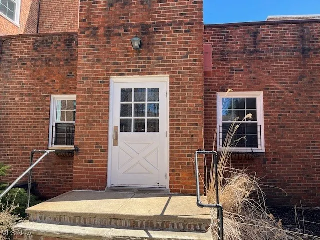 Property entrance featuring brick siding