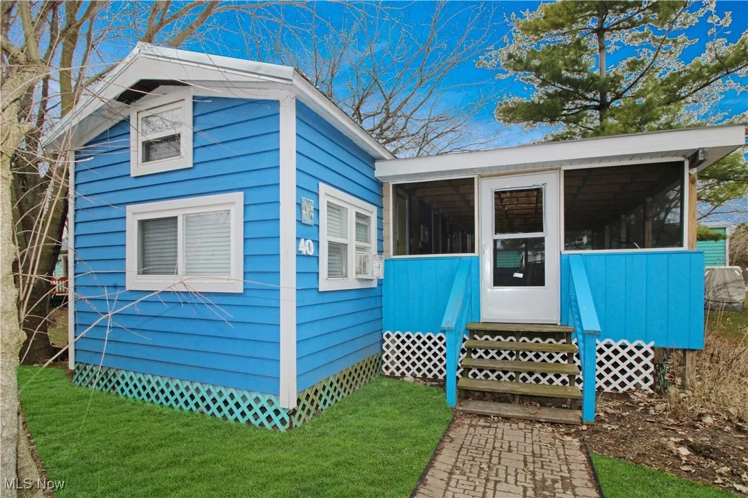 View of front of home with a front lawn, a sunroom, and entry steps