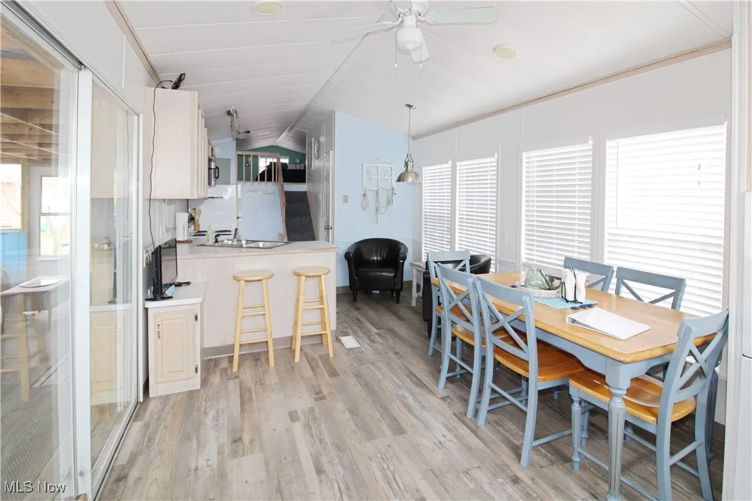 Dining area with light wood-type flooring, ceiling fan, and lofted ceiling
