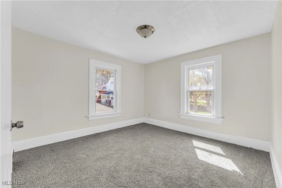 Empty room featuring carpet and baseboards