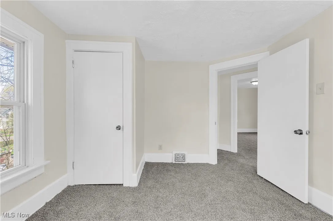 Spare room with light carpet, baseboards, and visible vents