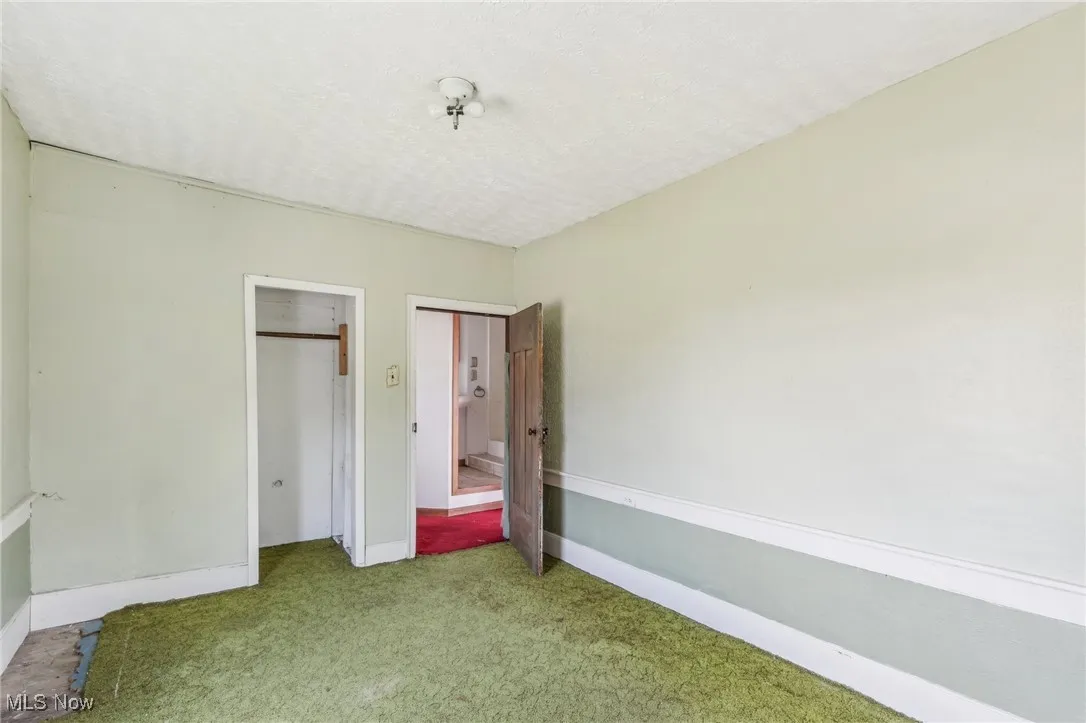 Unfurnished bedroom with baseboards, carpet floors, and a textured ceiling