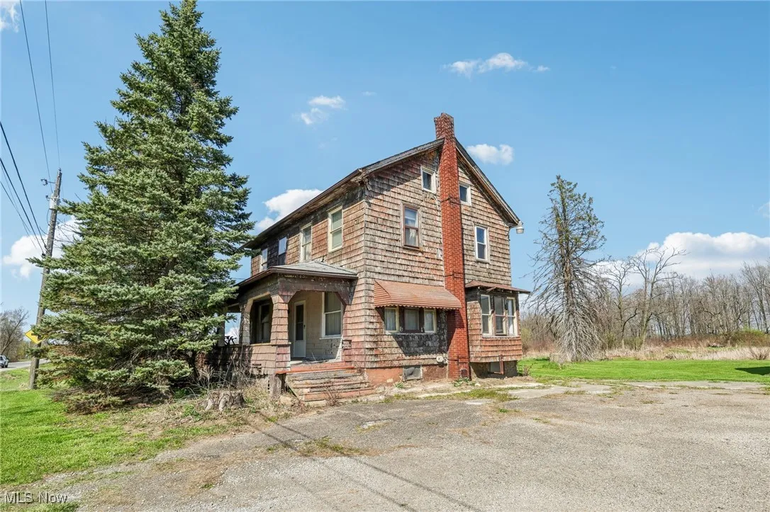View of home's exterior featuring a chimney and covered porch