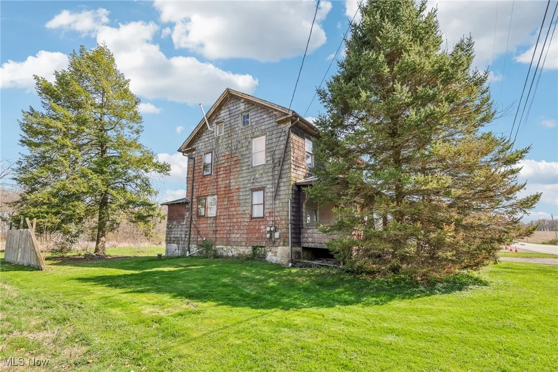 View of side of home with a yard