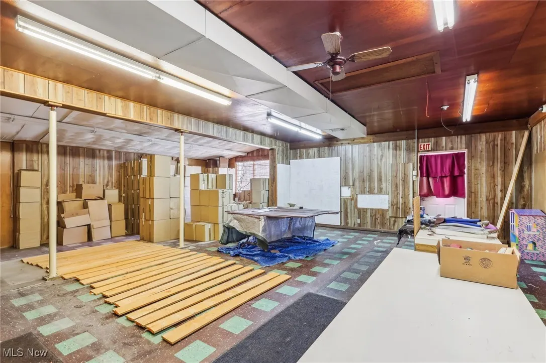 Showroom area with freestanding refrigerator and wood walls