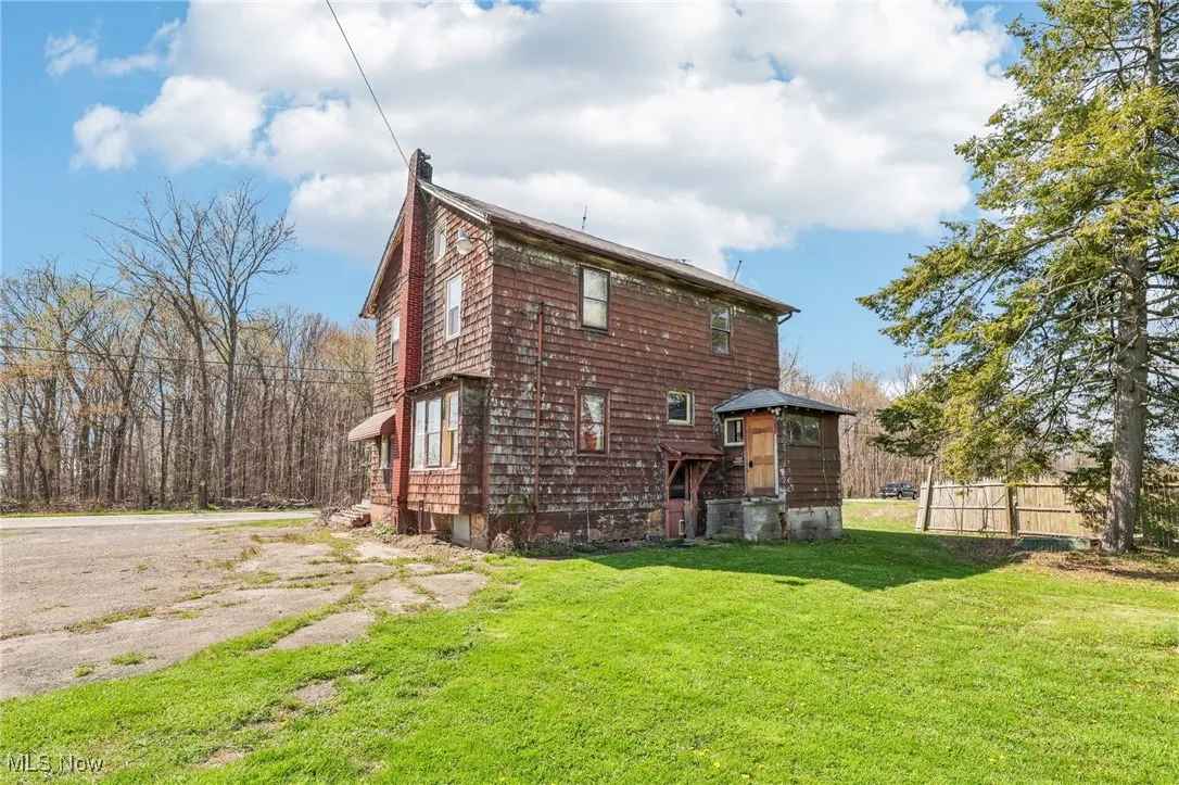 Rear view of property with a lawn and fence