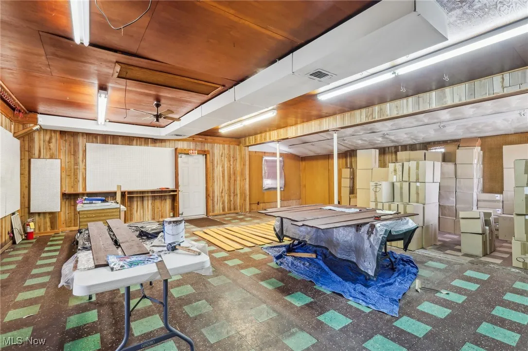 Showroom featuring wooden walls, visible vents, pool table, and a ceiling fan
