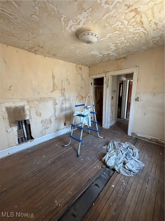 Unfurnished room featuring a fireplace and hardwood / wood-style flooring