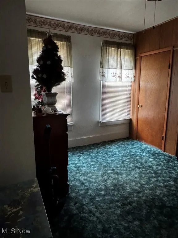 Unfurnished bedroom featuring carpet and baseboards