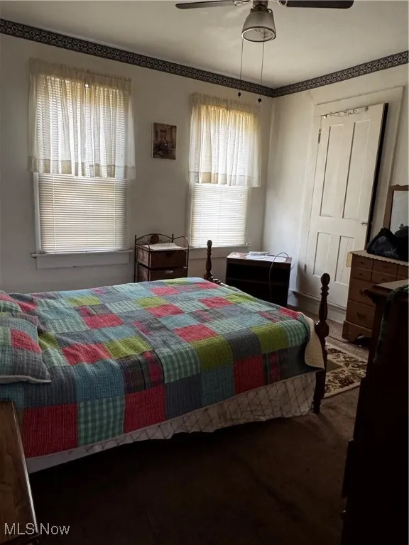 Bedroom featuring ceiling fan and carpet