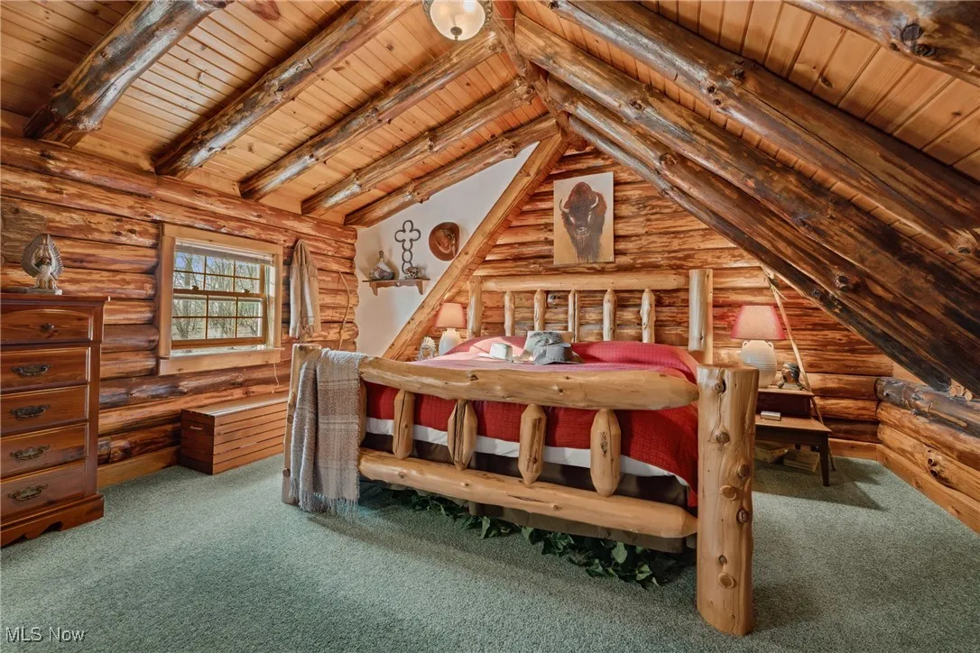 Unfurnished bedroom featuring wood ceiling, vaulted ceiling with beams, rail lighting, and carpet flooring