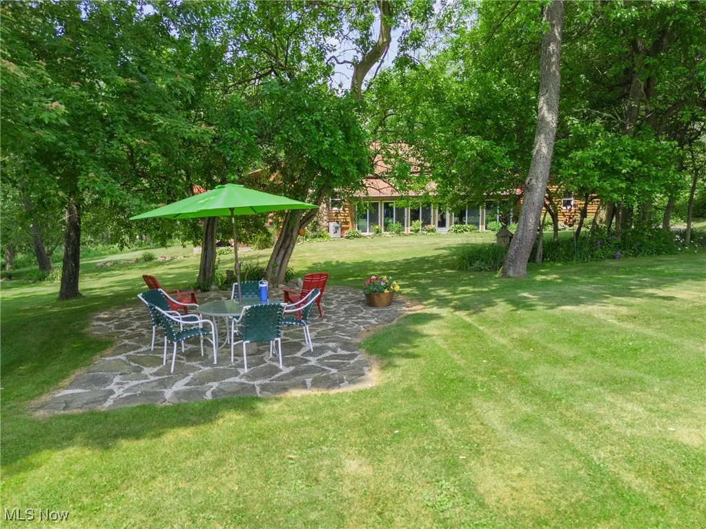 View of grassy yard featuring a patio