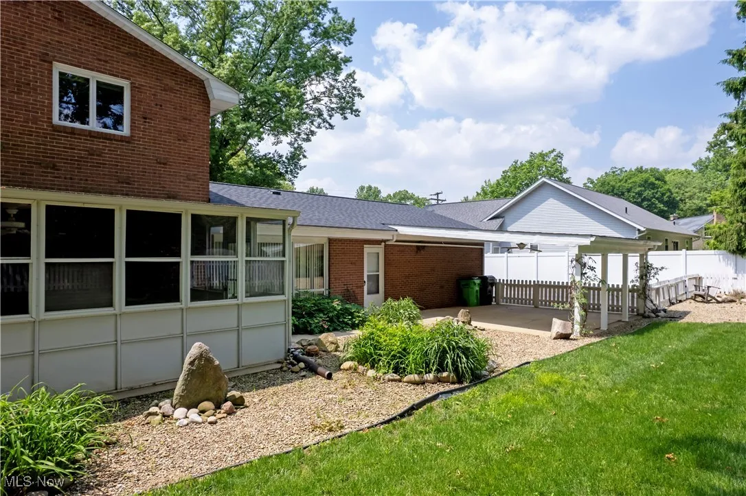 Back of property with a patio, a shingled roof, and brick siding