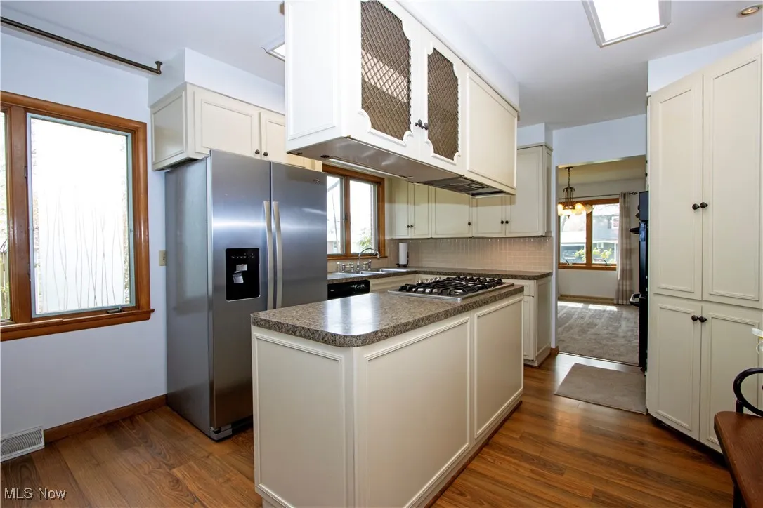 Kitchen featuring dark countertops, visible vents, appliances with stainless steel finishes, and a healthy amount of sunlight