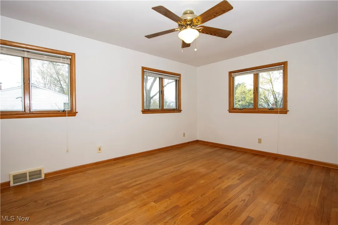 Unfurnished room featuring ceiling fan, baseboards, visible vents, and light wood-style flooring