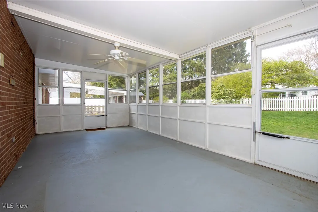 Unfurnished sunroom with a ceiling fan
