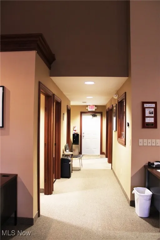 Hall featuring light colored carpet and baseboards