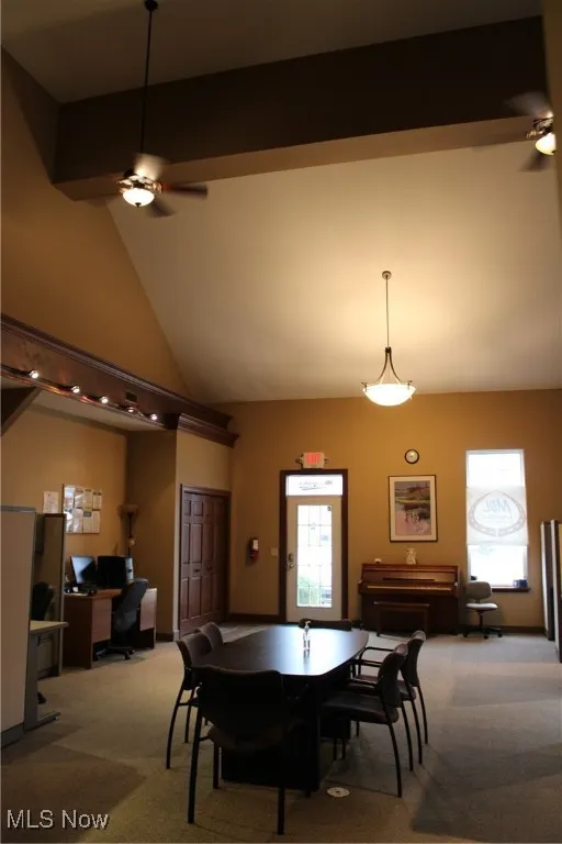 Dining area featuring carpet floors, high vaulted ceiling, and ceiling fan