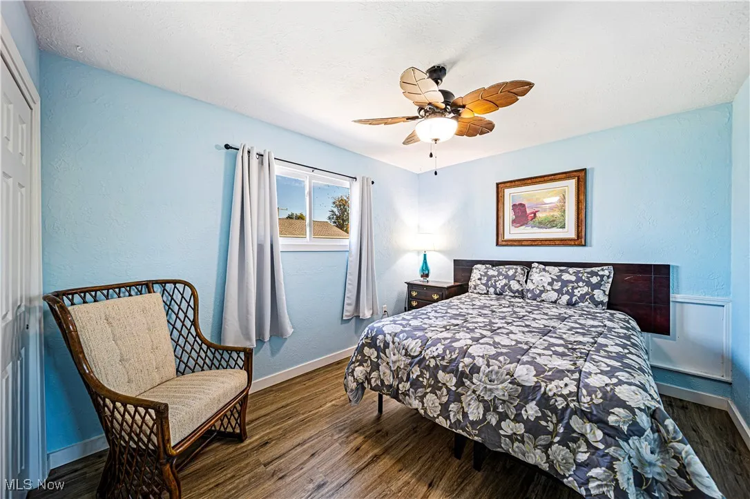 Bedroom with ceiling fan and dark wood-type flooring