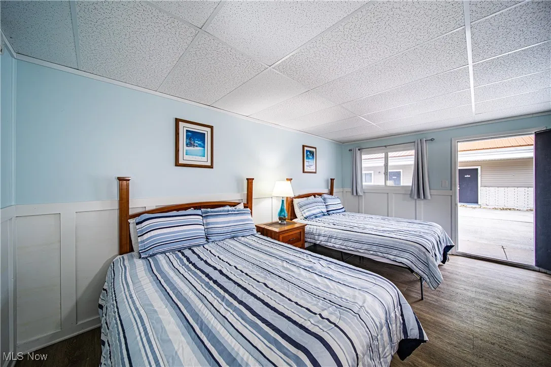 Bedroom with a paneled ceiling and dark hardwood / wood-style flooring